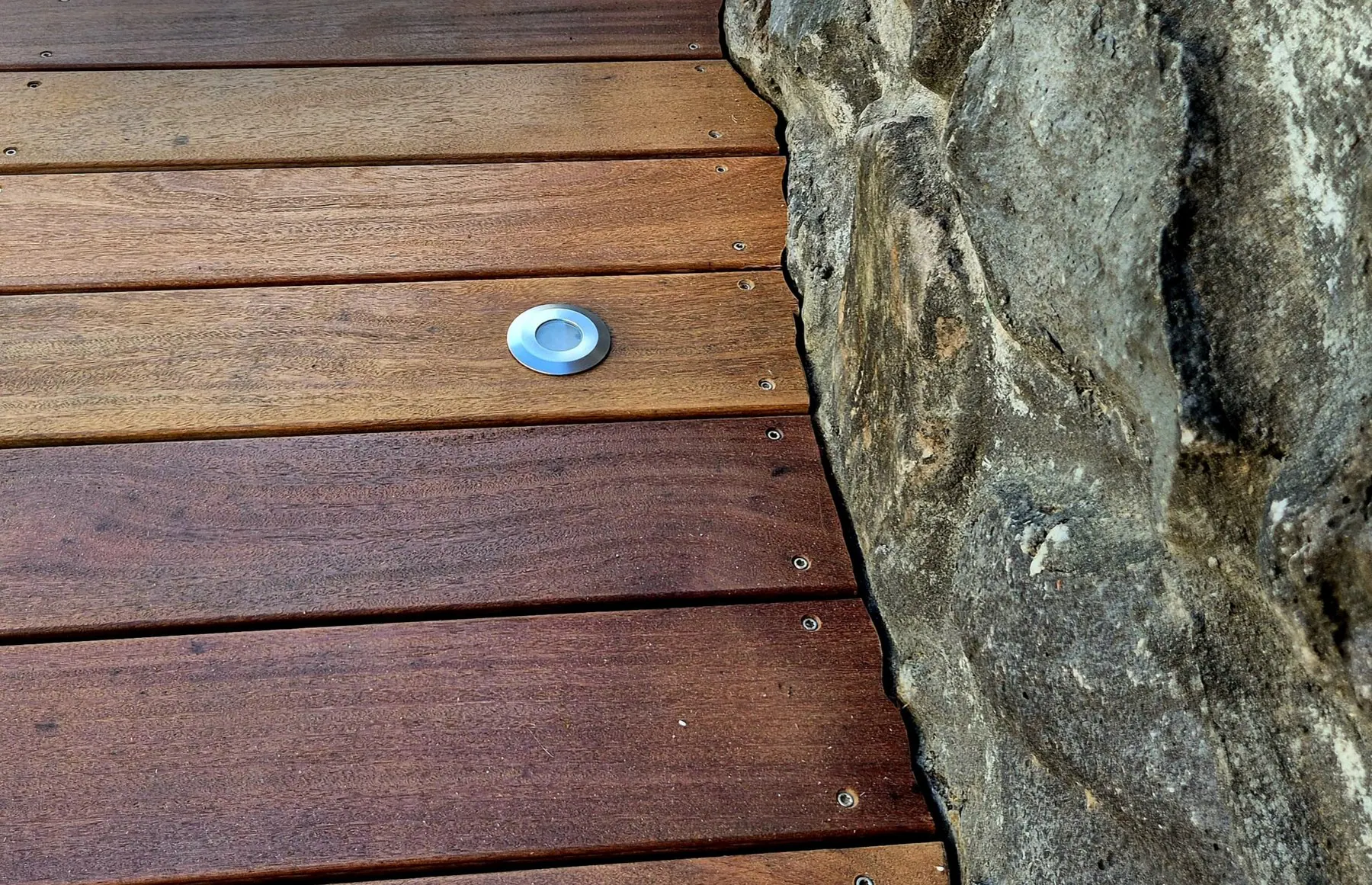 Terrasse bois ajustée à un mur de basalte